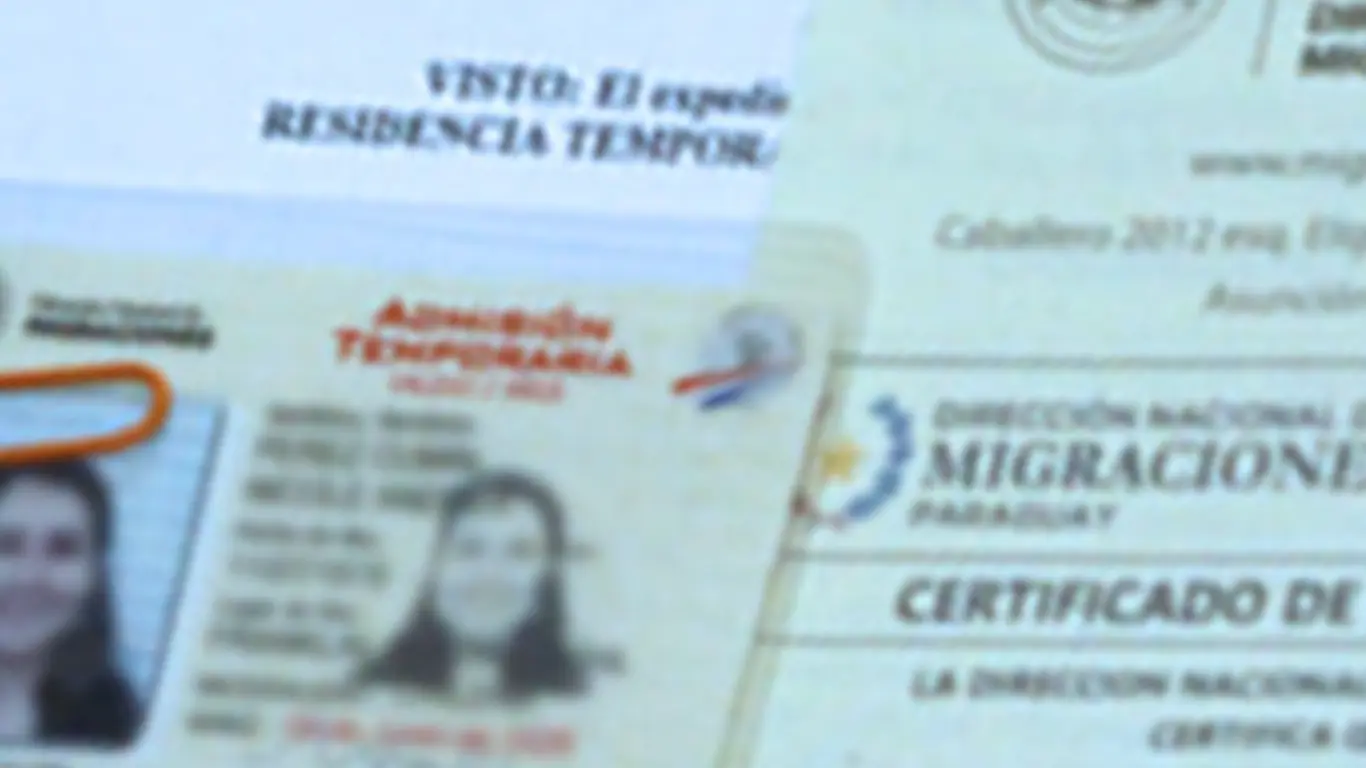 Close-up of a Paraguayan residency card with the accompanying Migraciones certificate